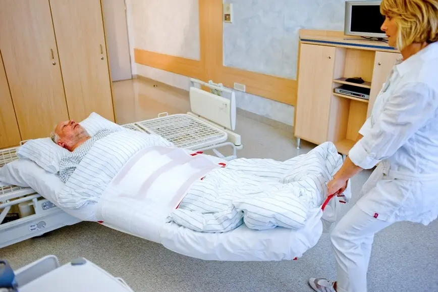 Evakuierung eines Patienten mit Hilfe einer Evakuierungsmatte in einem Krankenhaus, oder Pflegeeinrichtung während einer Brandschutzhelfer Ausbildung