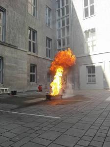 Vorführung einer Fettexplosion durch Löschversuch mit Wasser bei einer Brandschutzhelfer Ausbildung auf dem Innenhof einer Universität in Berlin